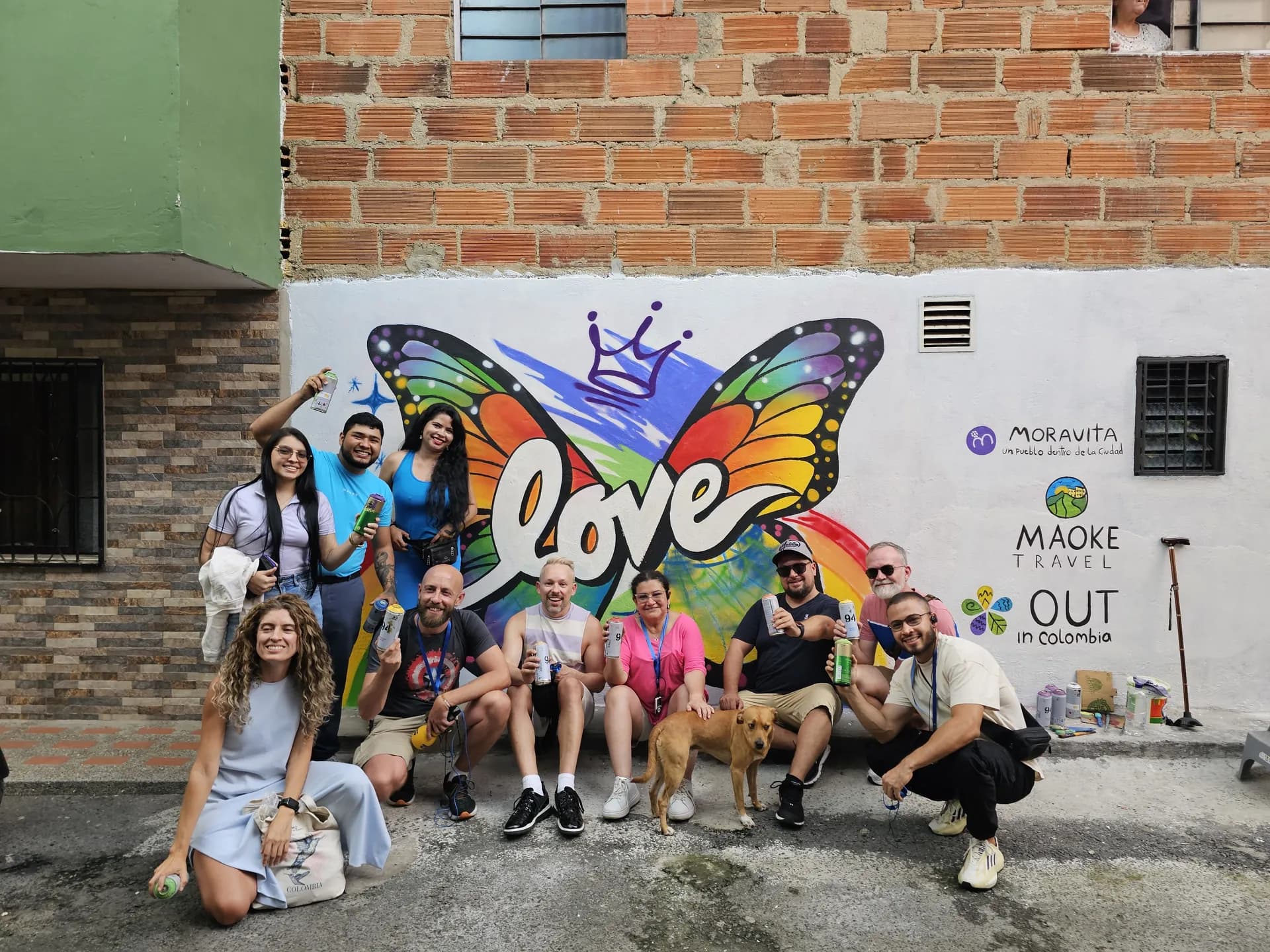 Grupo de viajeros de Maoke Travel frente a un mural en Medellín